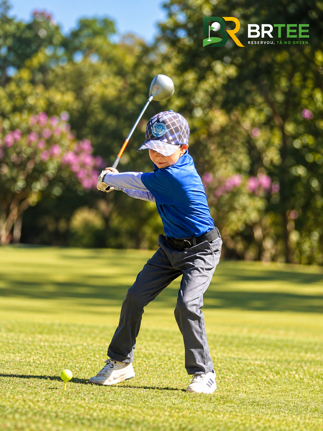 Criança dando sua primeira tacada de golfe com a BRTEE